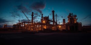 An illuminated industrial refinery at dusk