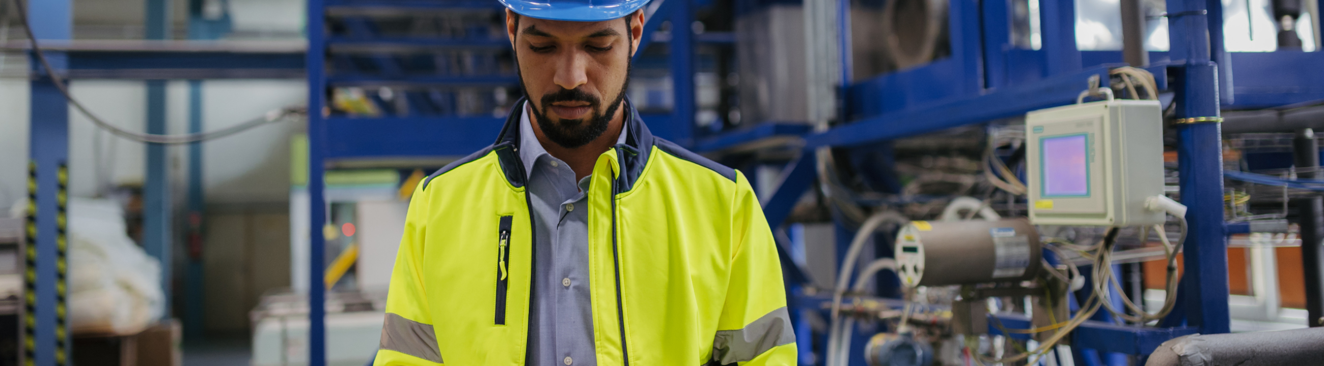 OT engineer reviewing patch management data on tablet in industrial facility