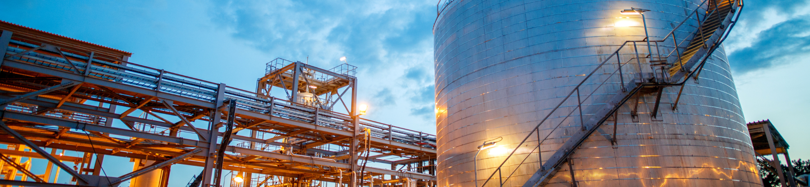 il and gas storage and processing facility at dusk representing OT cybersecurity compliance obligations across Gulf region critical infrastructure