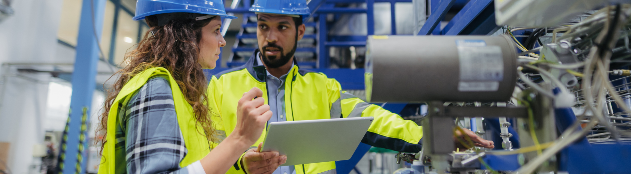 Control engineer assessing industrial control system with laptop in OT environment