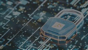 A stylized, digital image showing an industrial setting with factory machinery and a network of connected devices. A shield icon or padlock symbol is overlaid on the network, representing cybersecurity protection.